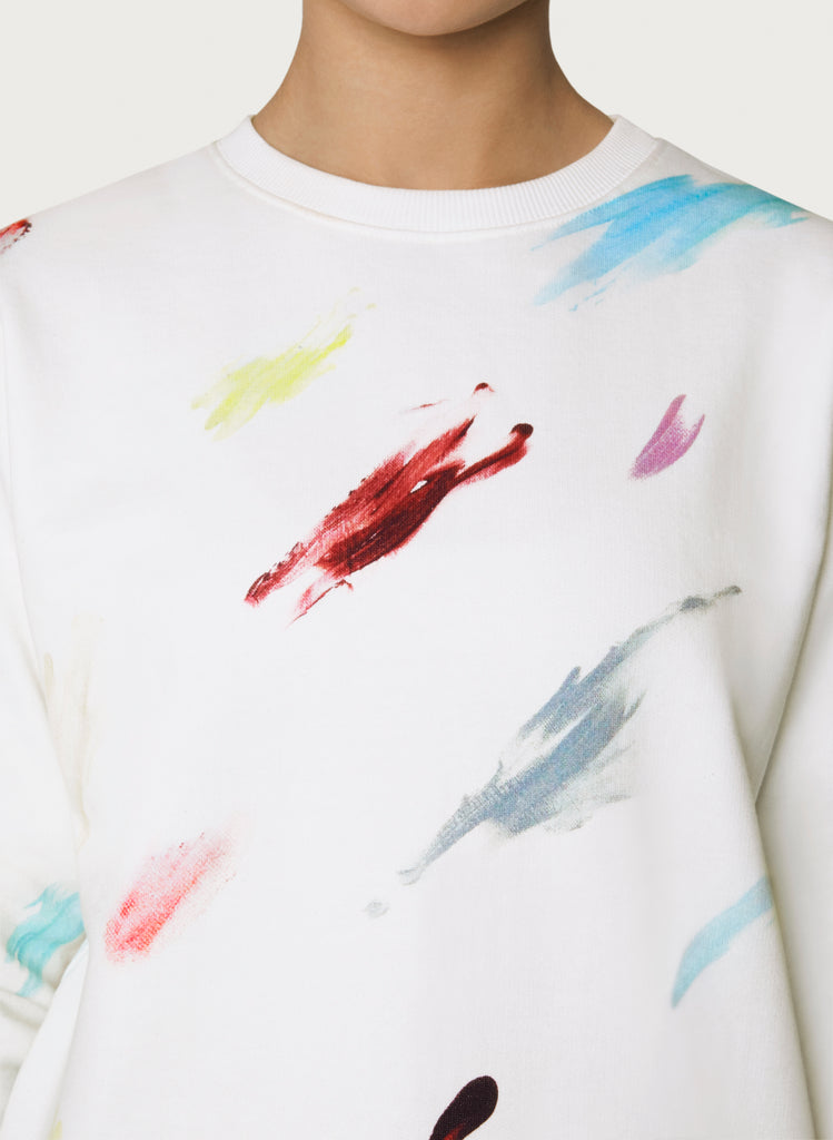 Female model wearing white sweatshirt with colourful artistic design. Wearable art hoodie made from organic cotton material. Front picture zoom.