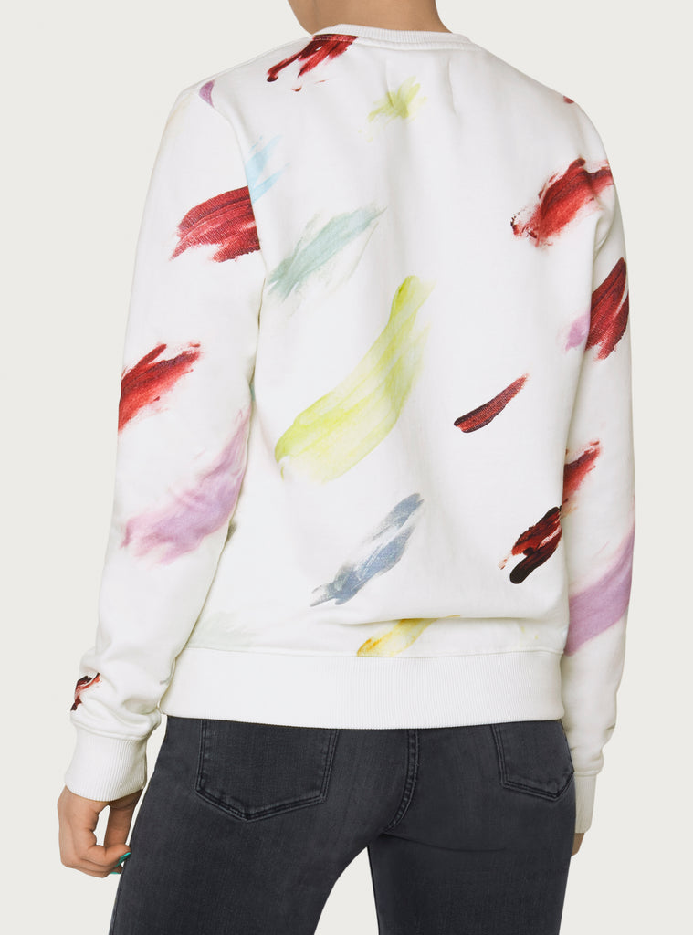 Female model wearing white sweatshirt with colourful artistic design. Wearable art hoodie made from organic cotton material. Back picture.