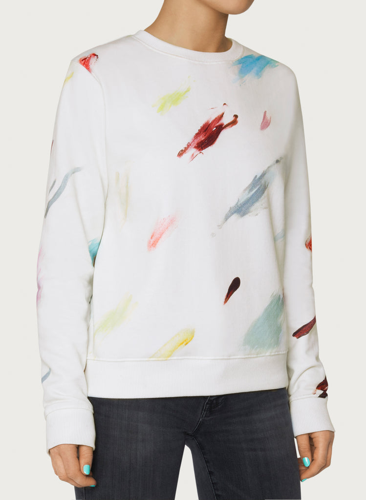 Female model wearing white sweatshirt with colourful artistic design. Wearable art hoodie made from organic cotton material. Front picture.