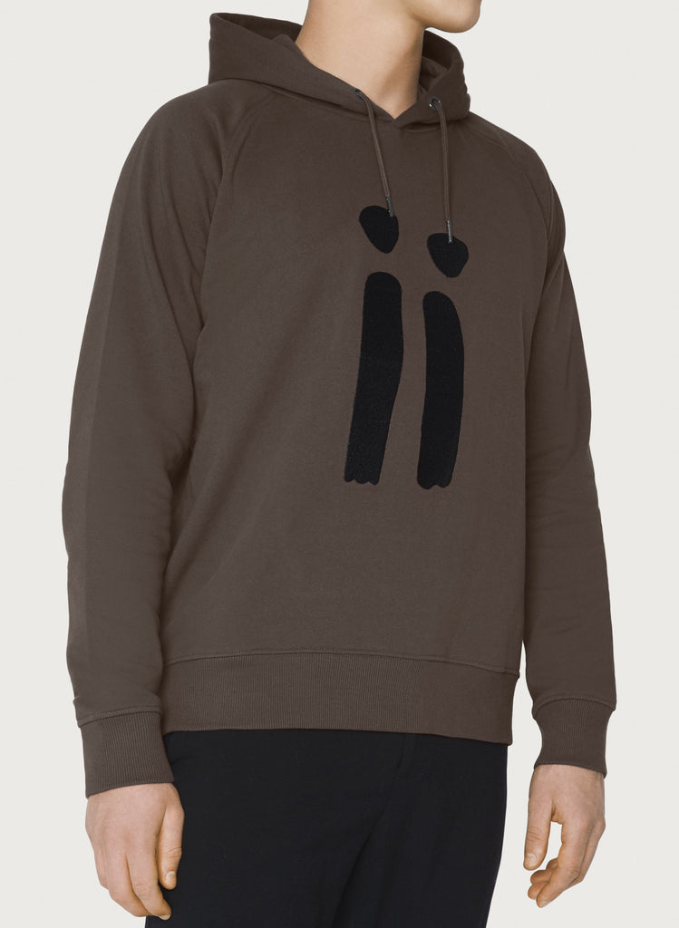 Male model presenting brown, unisex sweatshirt with ARTiiG logo on. Wearable art hoodie for him and her. Front picture.